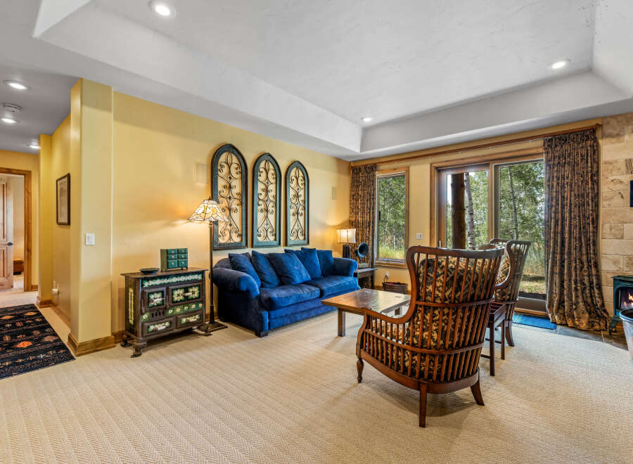 Experience cozy living in this inviting living room, featuring a plush blue sofa perfect for relaxation and a charming antique cabinet adding character.