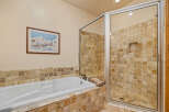 Indulge in relaxation in this luxurious bathroom featuring a spacious soaking tub and a separate glass-enclosed shower.