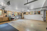 This spacious garage offers ample storage and organization solutions, featuring custom cabinetry, slatted wall panels for versatile hanging options, and overhead storage.