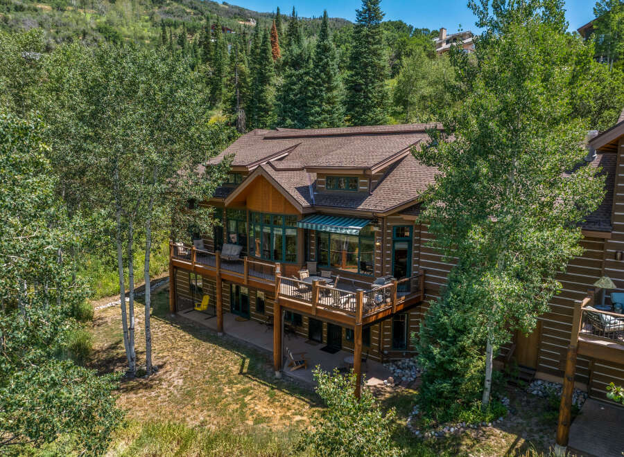Experience luxury mountain living in this stunning log-style home, nestled amidst lush greenery and mature trees.