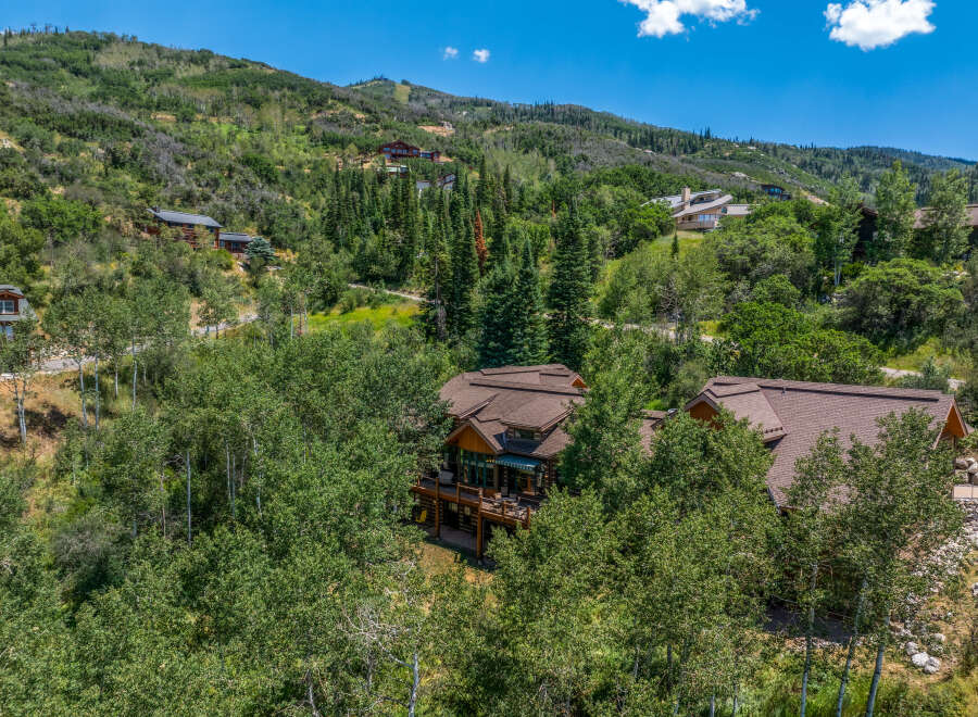 Nestled amidst lush greenery and mature trees, this stunning mountain home offers a serene escape with breathtaking views.