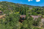 Nestled amidst lush greenery and mature trees, this stunning mountain home offers a serene escape with breathtaking views.
