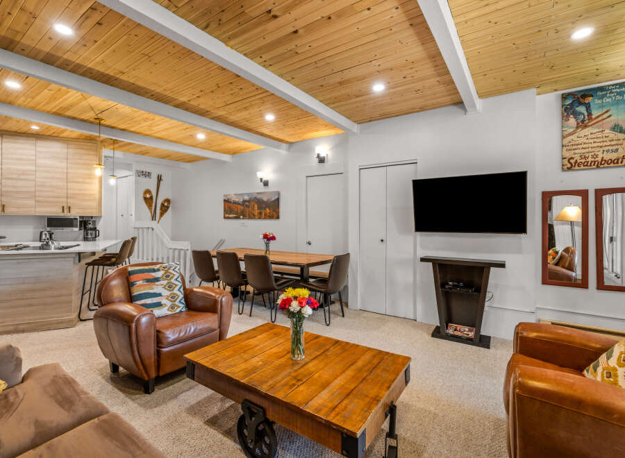 Experience the charm of this mountain retreat, featuring a stylish open-concept living area with a modern kitchen and a cozy dining space.