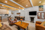 Experience the charm of this mountain retreat, featuring a stylish open-concept living area with a modern kitchen and a cozy dining space.