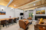 Experience cozy mountain living in this inviting living space featuring a warm fireplace and a rustic wooden dining table perfect for family gatherings.