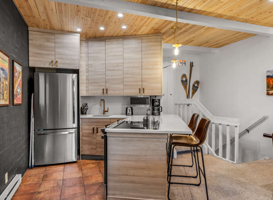 Experience modern mountain living in this beautifully updated kitchen, featuring sleek light wood cabinetry and a stunning waterfall island with bar seating.