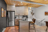 Experience modern mountain living in this beautifully updated kitchen, featuring sleek light wood cabinetry and a stunning waterfall island with bar seating.