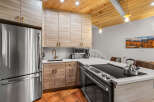 Experience modern living in this stunning kitchen featuring sleek, light wood cabinetry and a durable quartz countertop.