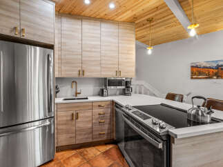 Experience modern living in this stunning kitchen featuring sleek, light wood cabinetry and a durable quartz countertop.