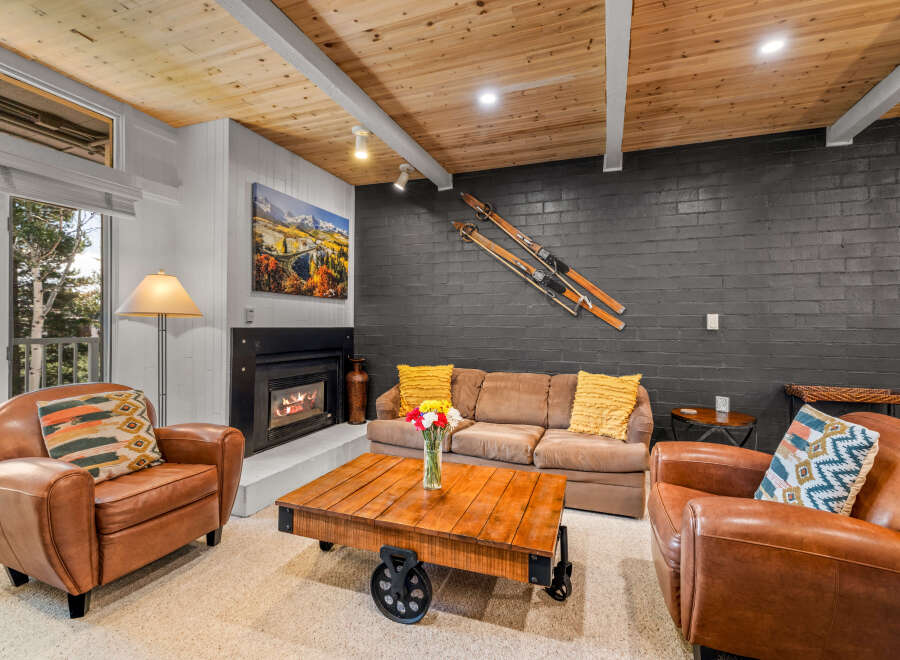 Cozy mountain living awaits in this inviting living room, featuring a warm fireplace and comfortable seating.