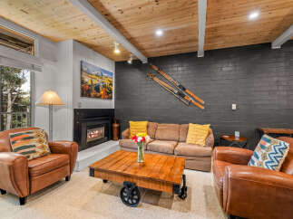 Cozy mountain living awaits in this inviting living room, featuring a warm fireplace and comfortable seating.