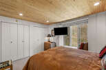 Experience cozy comfort in this charming bedroom, featuring a plush brown comforter and a rustic wicker nightstand.