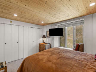 Experience cozy comfort in this charming bedroom, featuring a plush brown comforter and a rustic wicker nightstand.