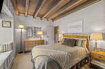 Experience cozy mountain living in this charming bedroom featuring a comfortable bed with a wicker headboard and plush bedding.