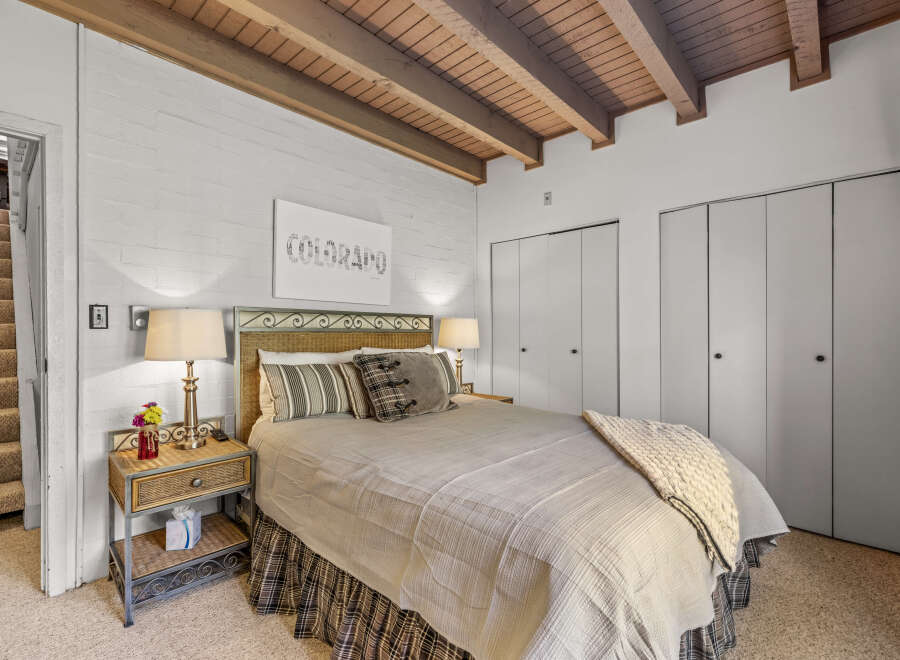 Discover this charming bedroom featuring a cozy queen-size bed with a wicker headboard, perfect for restful nights.