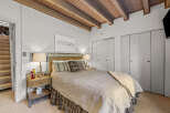 Discover this charming bedroom featuring a cozy queen-size bed with a wicker headboard, perfect for restful nights.