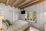 This charming bedroom features a cozy bed with plush pillows and a textured blanket, perfect for relaxation.