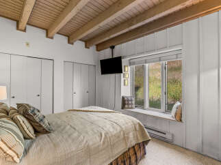 This charming bedroom features a cozy bed with plush pillows and a textured blanket, perfect for relaxation.