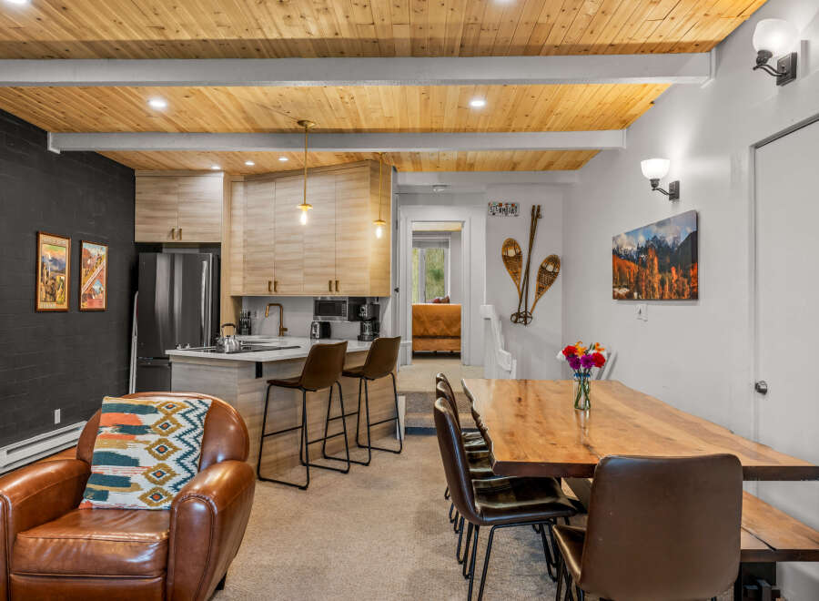 Experience cozy living in this charming space featuring a modern kitchen with light wood cabinetry and a breakfast bar, perfect for casual dining.