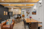 Experience cozy living in this charming space featuring a modern kitchen with light wood cabinetry and a breakfast bar, perfect for casual dining.