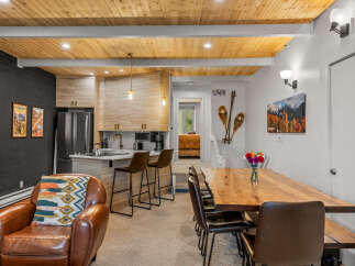 Experience cozy living in this charming space featuring a modern kitchen with light wood cabinetry and a breakfast bar, perfect for casual dining.