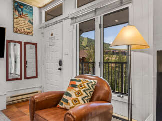 Experience the charm of Steamboat Springs with this inviting living space, featuring a cozy leather armchair adorned with a decorative pillow.