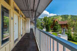 Enjoy the mountain views from this charming property's exterior walkway, offering a glimpse of the ski slopes and surrounding greenery.