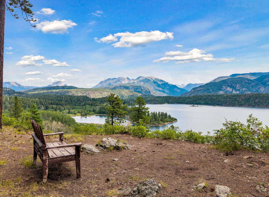 Experience breathtaking panoramic views from this stunning property, featuring a serene lake and majestic mountains.