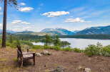 Experience breathtaking panoramic views from this stunning property, featuring a serene lake and majestic mountains.