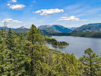 Experience breathtaking natural beauty with this stunning property offering panoramic views of a serene lake and majestic mountains.