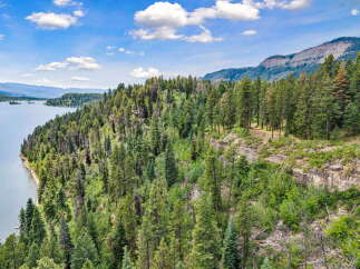 Discover breathtaking natural beauty with this stunning property overlooking a serene lake and majestic mountains.