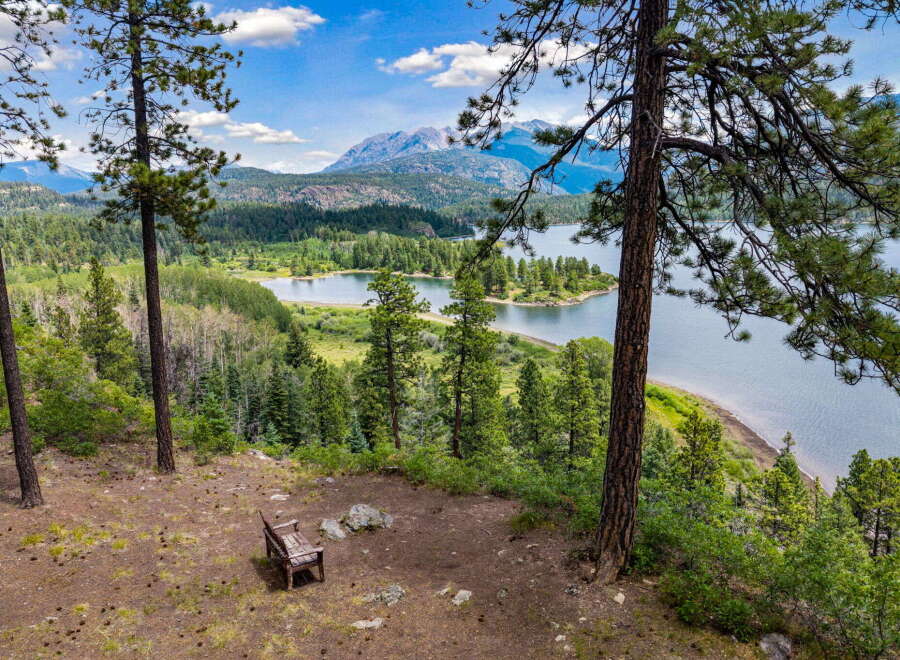 Experience breathtaking panoramic views from this stunning property, featuring a serene lake and majestic mountains as your backdrop.