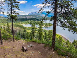 Experience breathtaking panoramic views from this stunning property, featuring a serene lake and majestic mountains as your backdrop.