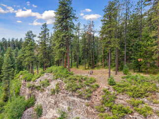 Experience breathtaking views from this stunning cliffside property, nestled amidst a serene pine forest.
