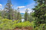 Experience breathtaking lake views from this stunning property, nestled amongst mature pine trees and lush greenery.
