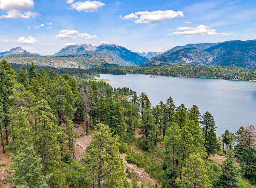 Discover breathtaking natural beauty with this stunning property offering panoramic views of a serene lake and majestic mountains.