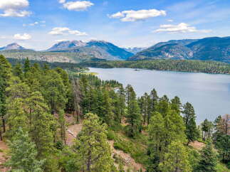 Discover breathtaking natural beauty with this stunning property offering panoramic views of a serene lake and majestic mountains.