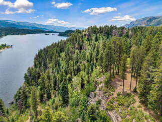 Discover breathtaking natural beauty with this stunning property overlooking a serene lake and majestic mountains.
