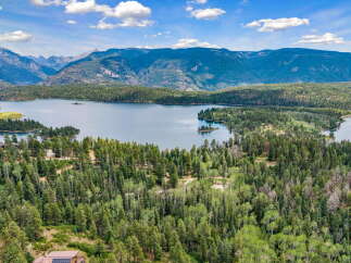 Experience breathtaking mountain and lake views from this stunning property, nestled amidst a lush forest.
