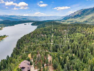 Discover this stunning property offering breathtaking panoramic views of the serene lake and majestic mountains.