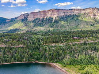 Nestled amidst a lush forest and overlooking a serene lake, this property offers a private mountain retreat.