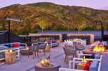 Experience luxury outdoor living with this stunning rooftop patio, featuring comfortable seating areas, a cozy fire pit, and breathtaking mountain views.