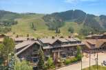 Experience luxury mountain living in this stunning property, featuring a grand lodge-style building with multiple balconies and large windows.
