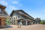 Discover this charming commercial property featuring a multi-story building with a rustic stone facade and shingle siding, perfect for retail or office spaces.