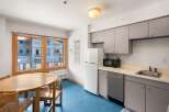 This charming kitchen and dining area features a round wooden dining table with chairs, perfect for intimate meals.