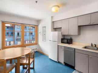 This charming kitchen and dining area features a round wooden dining table with chairs, perfect for intimate meals.