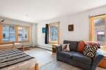 This cozy living space features two comfortable beds and a plush sofa, perfect for relaxing after a day of adventure.