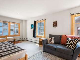 This cozy living space features two comfortable beds and a plush sofa, perfect for relaxing after a day of adventure.