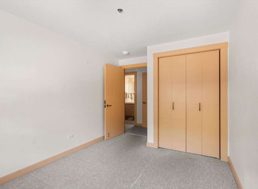 Step into this inviting room featuring a spacious closet with light wood doors, perfect for ample storage.