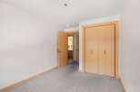Step into this inviting room featuring a spacious closet with light wood doors, perfect for ample storage.